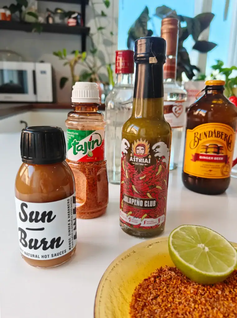 Moscow Mule -ainekset vaihtoehtoiseen Tajín-reunalliseen versioon. Tajinia, inkivääriolutta ja erilaisia chilikastikkeita.